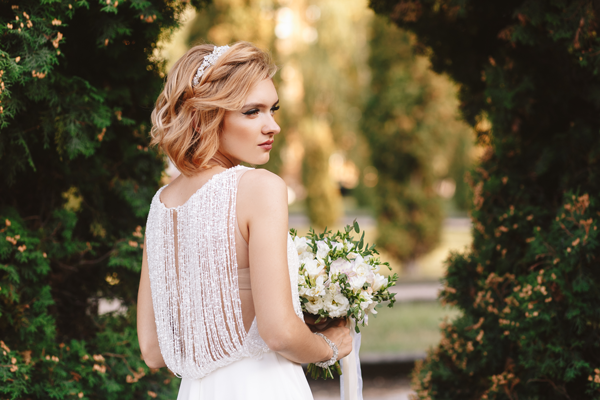 Blonde Braut in wunderschönen Vintage Brautkleid im Park